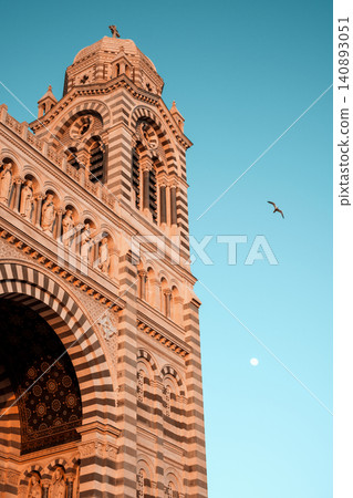 Stunning sunset over marseille cathedral: architecture against clear sky with bird and moon Stunning sunset over marseille cathedral: architecture against clear sky with bird and moon 140893051