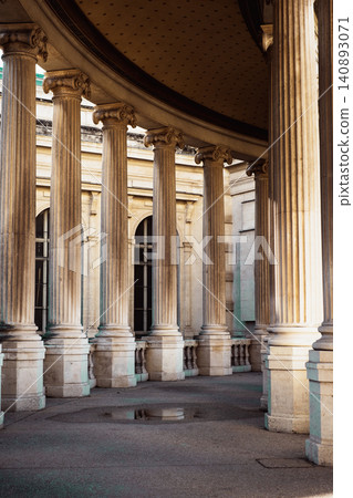 Elegant sunlit colonnade with classical architecture and majestic pillars Elegant sunlit colonnade with classical architecture and majestic pillars 140893071