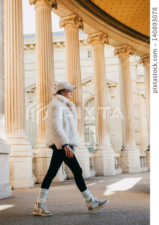 Chic urban style: woman in fur coat and cap strolling past classical architecture Chic urban style: woman in fur coat and cap strolling past classical architecture 140893078