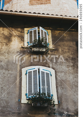 Rustic building with blue shutters and ivy in urban setting Rustic building with blue shutters and ivy in urban setting 140893095