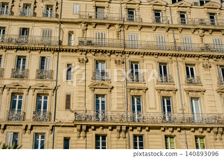 Charming parisian architecture with classic balconies and ornate facades in warm afternoon light Charming parisian architecture with classic balconies and ornate facades in warm afternoon light 140893096