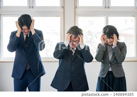 Business team holding their heads Business team holding their heads 140894385