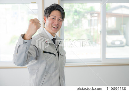 A staff member on site smiles and makes a victory pose. 140894388