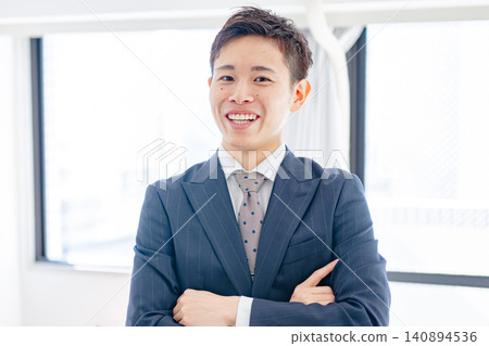 A businessman with his arms crossed and a smile on his face. A businessman with his arms crossed and a smile on his face. 140894536