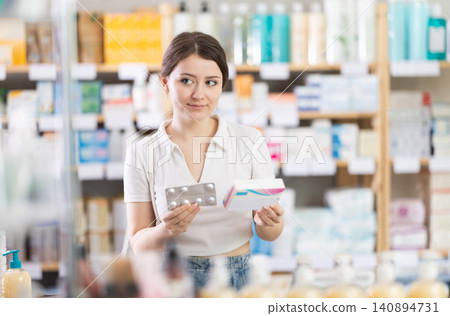 Girl in summer clothes looking for medicine in pharmacy Girl in summer clothes looking for medicine in pharmacy 140894731