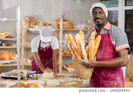 Adult man baker with basket of baguettes Adult man baker with basket of baguettes 140894993