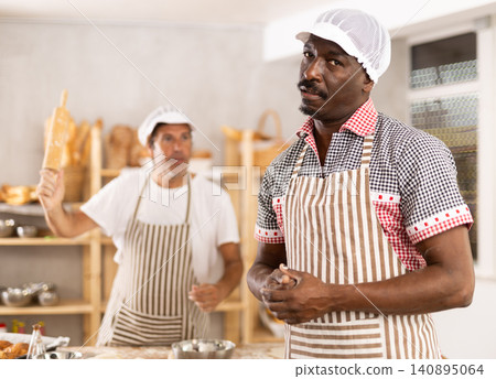 Disheartened African artisan baker scolded by partner in bakery Disheartened African artisan baker scolded by partner in bakery 140895064