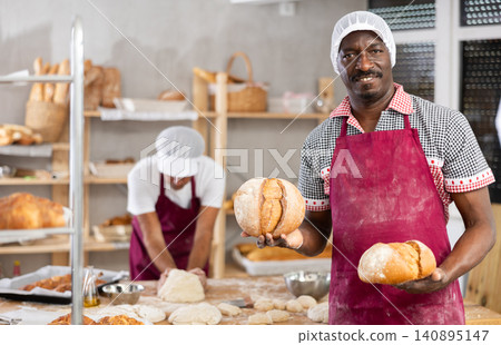 Professional African baker presenting freshly baked bread Professional African baker presenting freshly baked bread 140895147
