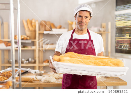 Adult male baker with basket of baguettes Adult male baker with basket of baguettes 140895221