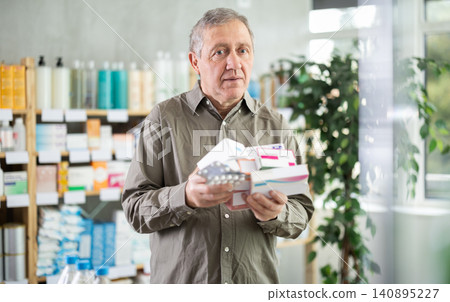 Senior male customer in drugstore with pile of pills. Senior male customer in drugstore with pile of pills. 140895227