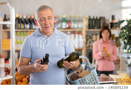Elderly man choosing olive oil in grocery store 140895239
