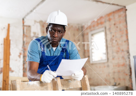 Portrait of man builder with project documentation Portrait of man builder with project documentation 140895278