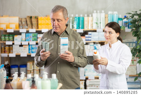 Man choosing cream with help from pharmacist Man choosing cream with help from pharmacist 140895285