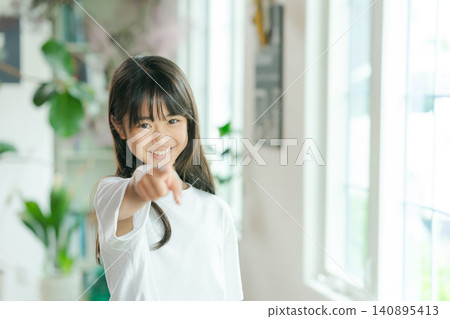 A smiling elementary school student points at the camera. A smiling elementary school student points at the camera. 140895413