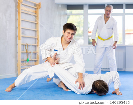 Adult and young men training judo fight Adult and young men training judo fight 140895455
