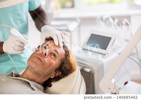 Adult male patient undergoing radiofrequency facial tightening procedure Adult male patient undergoing radiofrequency facial tightening procedure 140895482