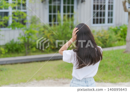 一名小學生雙手抱頭，背對著鏡頭。 140895643
