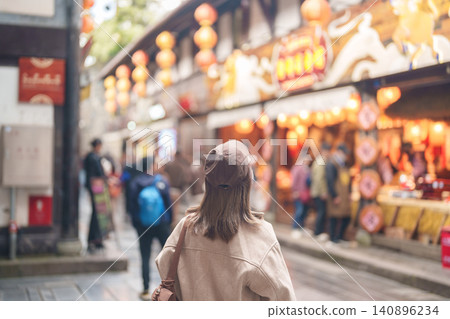 Happy woman traveler travel in Chengdu city. Tourist sightseeing and shopping in Jinli Ancient Street. Famous Landmark for tourism attraction in Sichuan, China Happy woman traveler travel in Chengdu city. Tourist sightseeing and shopping in Jinli Ancient Street. Famous Landmark for tourism attraction in Sichuan, China 140896234