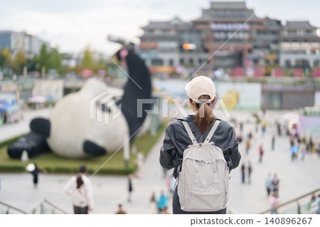 Happy woman traveler travel in Dujiangyan city. Tourist sightseeing Yangtianwo Square and Guanxian Ancient City near Chengdu. Landmark and popular for tourism attraction in Sichuan, China Happy woman traveler travel in Dujiangyan city. Tourist sightseeing Yangtianwo Square and Guanxian Ancient City near Chengdu. Landmark and popular for tourism attraction in Sichuan, China 140896267