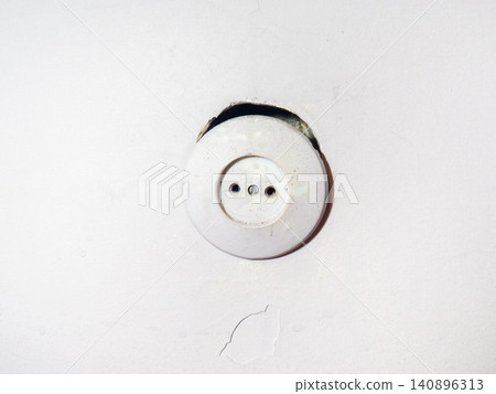 Old socket on a white wall. Home electricity concept. Needs renovation. 140896313