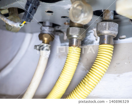Part of gas equipment. Hoses in a gas water heater. Gas flows through these pipes at home. 140896329