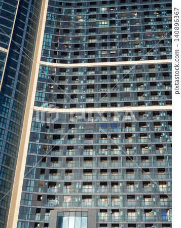 Glass facade of a house under construction with open windows. Windows opening outwards. Geometry in architecture. Glass facade of a house under construction with open windows. Windows opening outwards. Geometry in architecture. 140896367