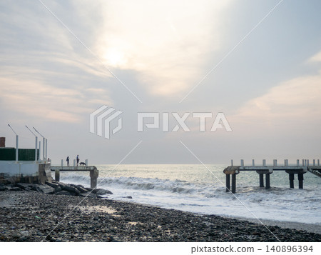 Destroyed pier under the waves. Bad weather at sea. Beautiful seashore with old architecture. Destroyed pier under the waves. Bad weather at sea. Beautiful seashore with old architecture. 140896394