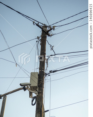 Old power line. New street camera on an old pole. Electricity supply to the population in Asia Old power line. New street camera on an old pole. Electricity supply to the population in Asia 140896415
