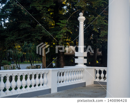 White decorative column in the park. Park decoration. Architecture of the resort town. White decorative column in the park. Park decoration. Architecture of the resort town. 140896428