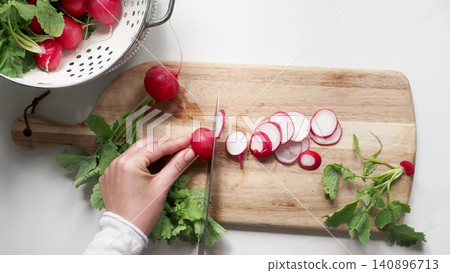 Hands slicing fresh red radishes Hands slicing fresh red radishes 140896713