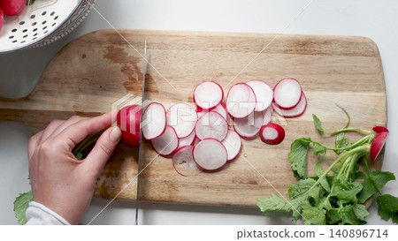 Hands slicing fresh red radishes Hands slicing fresh red radishes 140896714