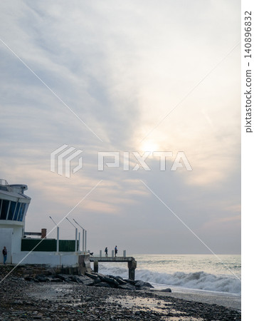 Destroyed pier under the waves. Bad weather at sea. Beautiful seashore with old architecture. Destroyed pier under the waves. Bad weather at sea. Beautiful seashore with old architecture. 140896832