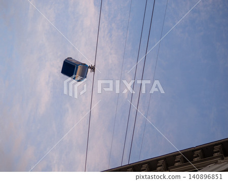 Cabins on a rope. Ropeway. Cabin silhouette. Road in the city on a lift Cabins on a rope. Ropeway. Cabin silhouette. Road in the city on a lift 140896851