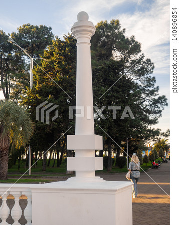 White decorative column in the park. Park decoration. Architecture of the resort town. White decorative column in the park. Park decoration. Architecture of the resort town. 140896854