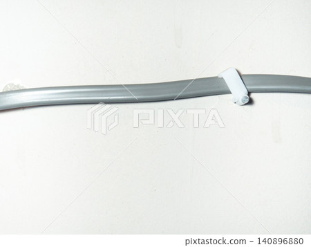 Fastening the wire to the wall. Ceiling mounting. Electric cord in the apartment. 220 volt. Fastening the wire to the wall. Ceiling mounting. Electric cord in the apartment. 220 volt. 140896880