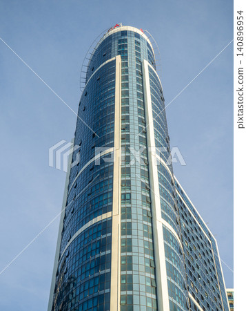 Glass facade of a house under construction with open windows. Windows opening outwards. Geometry in architecture. Glass facade of a house under construction with open windows. Windows opening outwards. Geometry in architecture. 140896954