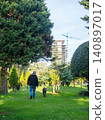 A man walks a large dog in the park. Back view. Retreating figures of a man and a dog. Vacation with a pet at the resort. 140897017