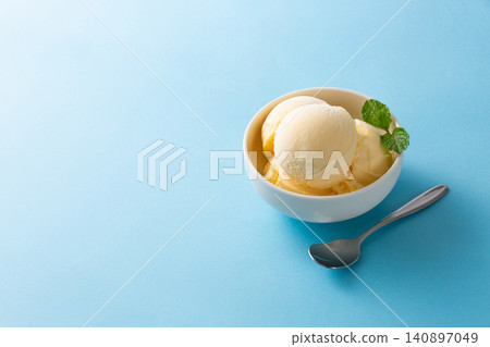 Cold vanilla ice cream against a blue background Cold vanilla ice cream against a blue background 140897049