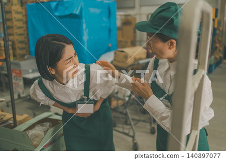 A senior staff member helps a young female staff member who is feeling unwell in the back room. A senior staff member helps a young female staff member who is feeling unwell in the back room. 140897077