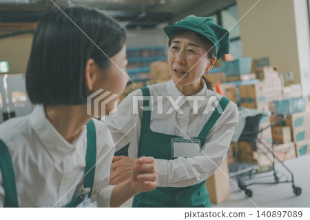 一位資深員工擔心超市後倉的一位初級同事。 一位資深員工擔心超市後倉的一位初級同事。 140897089