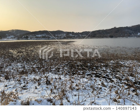 Golden sunset on pond with snowy hills Korea Golden sunset on pond with snowy hills Korea 140897143