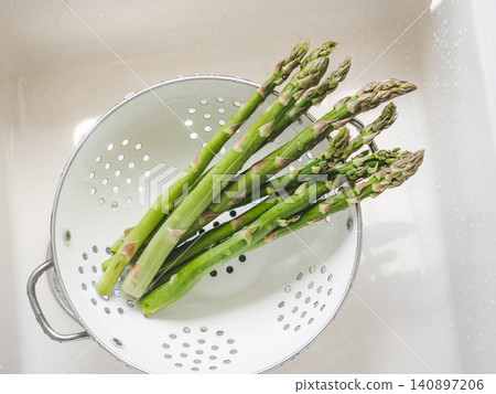 Green sprouts asparagus in a colander Green sprouts asparagus in a colander 140897206