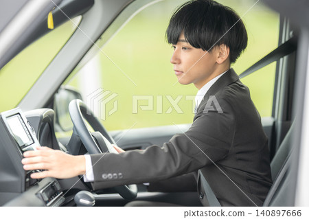 A businessman operating the navigation system inside his car. A businessman operating the navigation system inside his car. 140897666