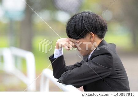 A young businessman troubled in a park A young businessman troubled in a park 140897915