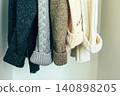 Colorful knitted sweaters hanging on a clothesline outdoors 140898205
