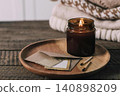 Dark glass jar with candle on a wooden tray with matches 140898209