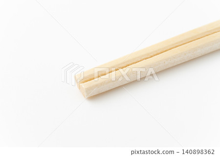 Close-up of the tip of a disposable chopstick against a white background Close-up of the tip of a disposable chopstick against a white background 140898362