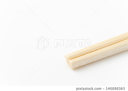 Close-up of the tip of a disposable chopstick against a white background Close-up of the tip of a disposable chopstick against a white background 140898363