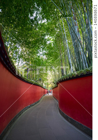 Traditional chinese red walls leading through bamboo forest Traditional chinese red walls leading through bamboo forest 140898671