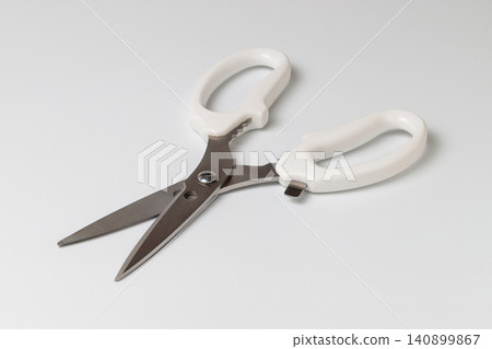 Kitchen scissors with a bottle opener, positioned diagonally against a white background. Kitchen scissors with a bottle opener, positioned diagonally against a white background. 140899867